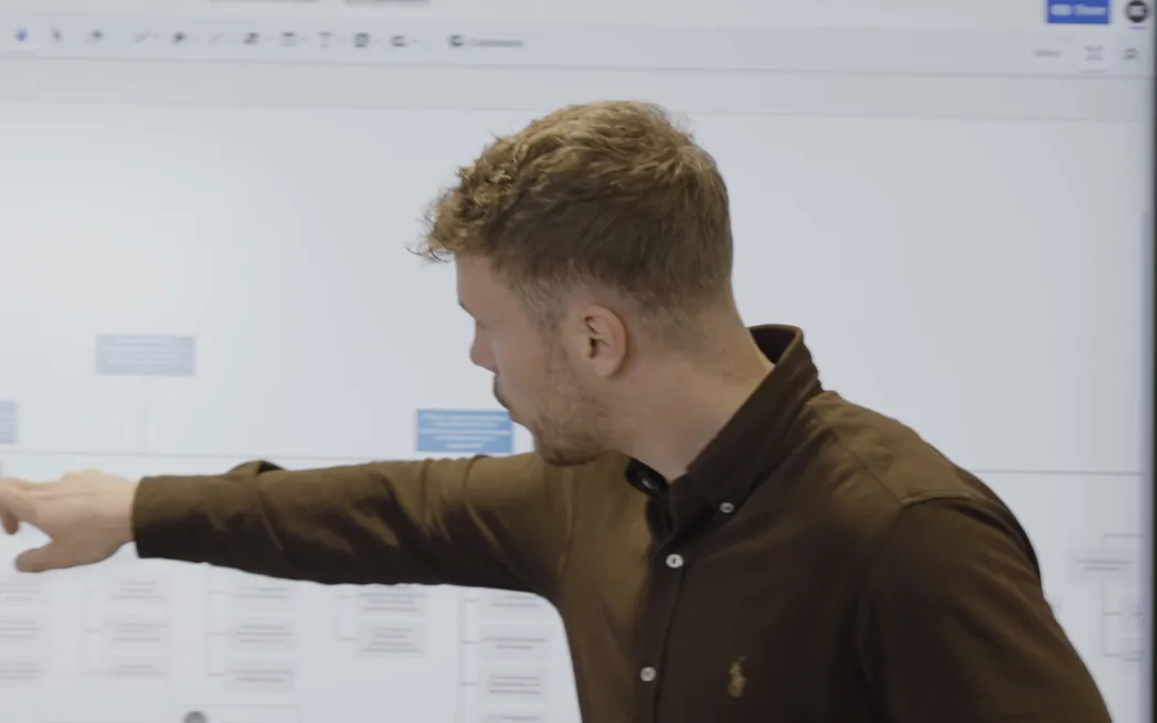 Nico Weidemann zeigt auf den Projektplan am Bildschirm